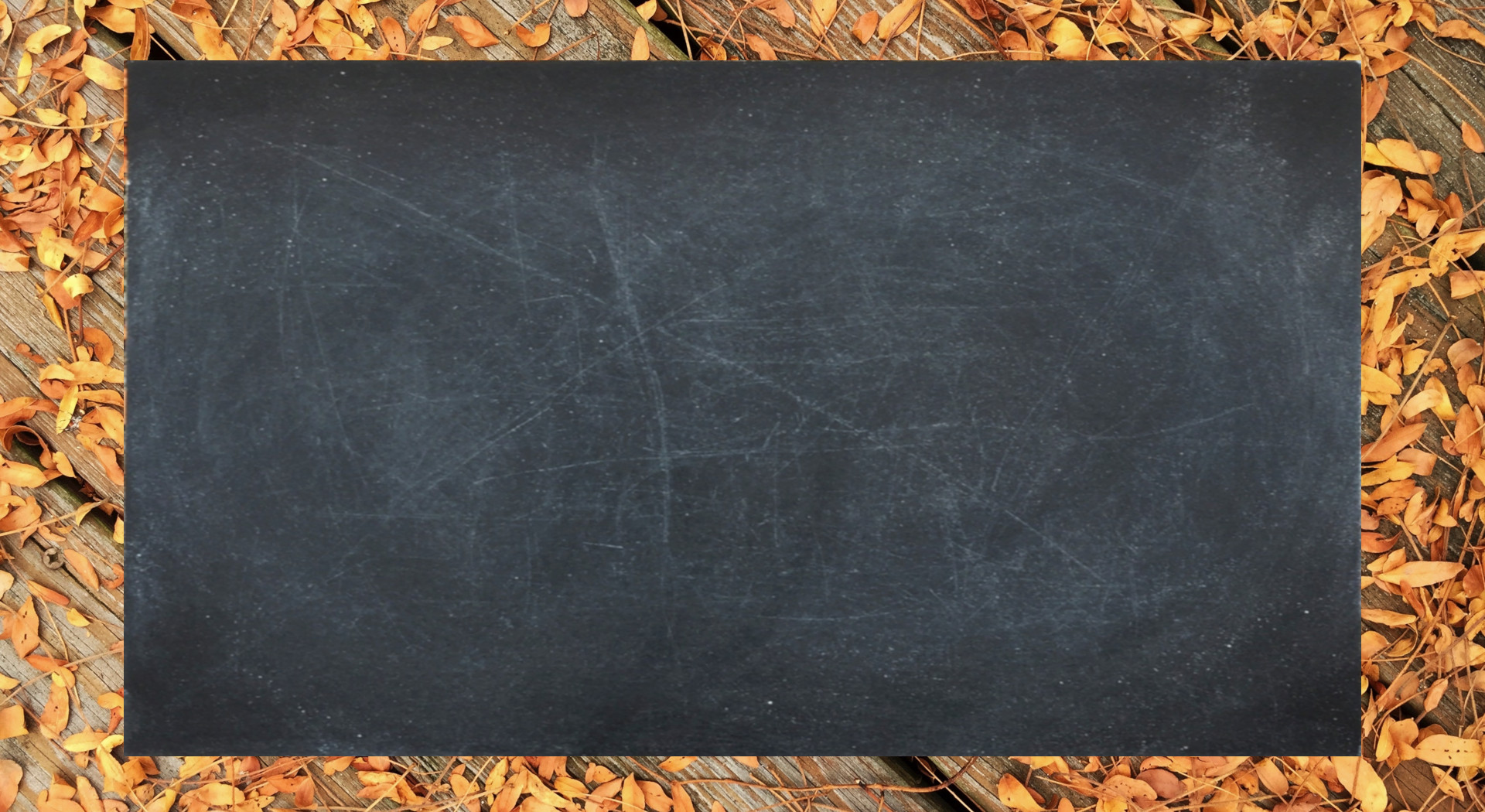 Place card with a dark chalkboard panel framed by orange autumn leaves on wood