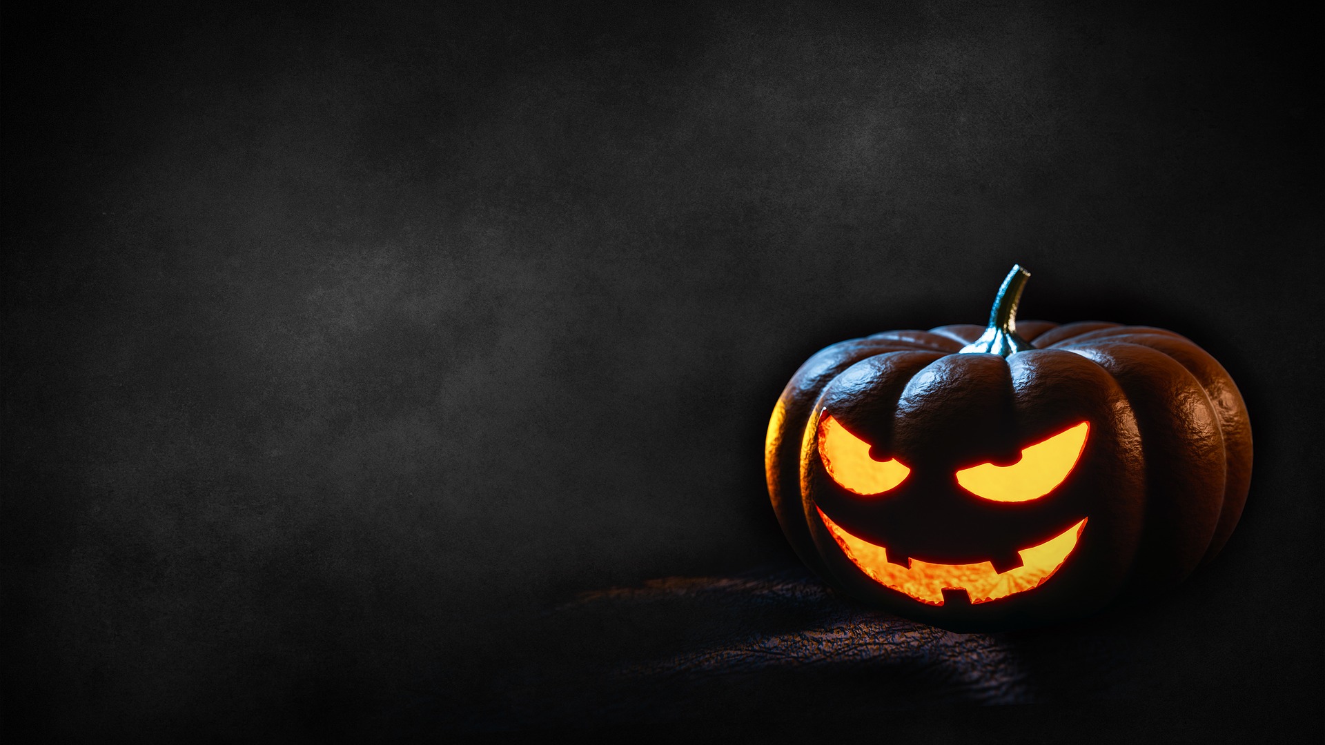 Place card with a glowing carved jack-o'-lantern on a dark charcoal background