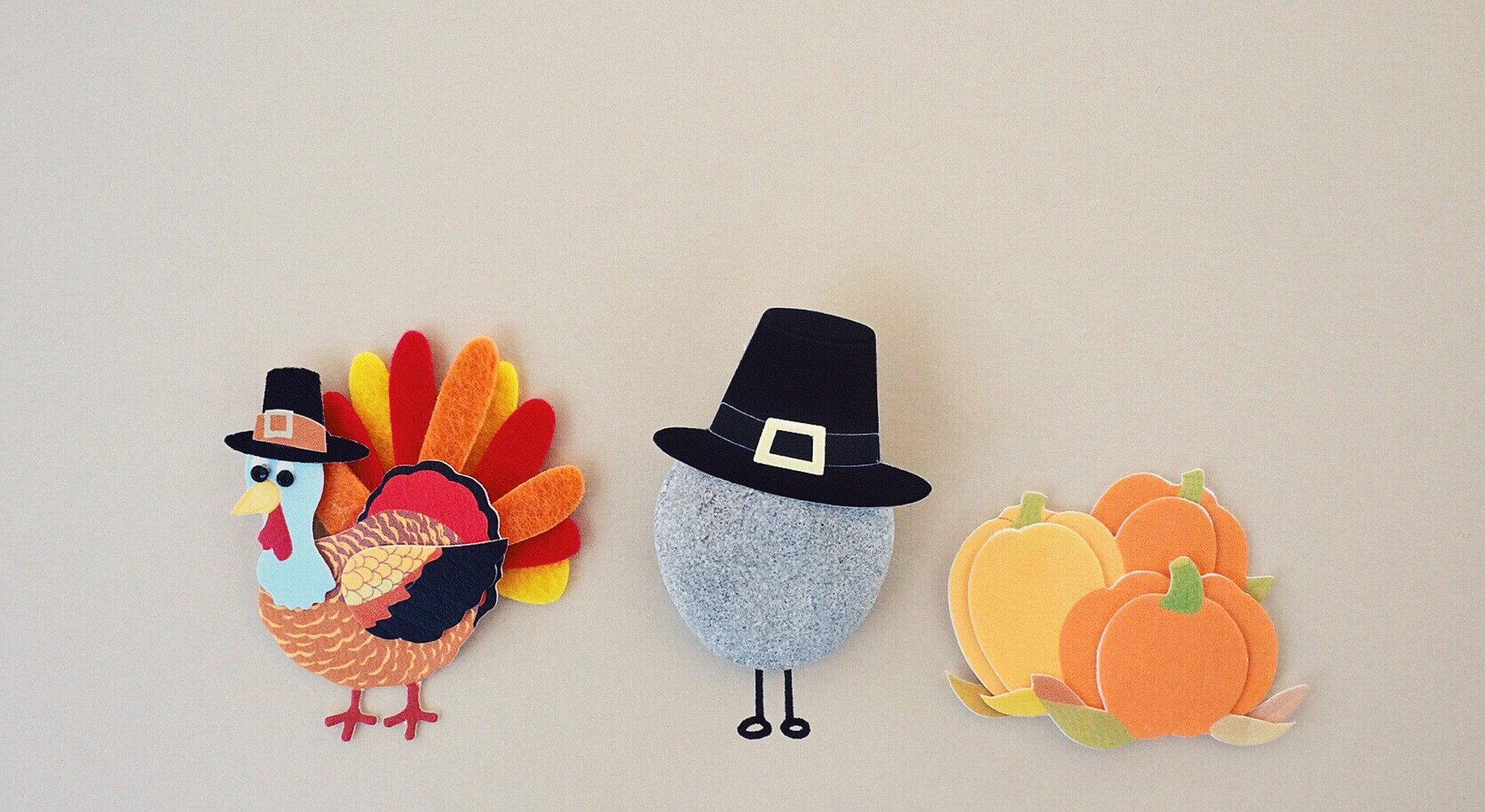 Place card with paper cutouts of a pilgrim turkey, hat and pumpkins